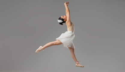 Elegant ballerina leaps mid-air in a graceful pose highlighting beauty and artistry of dance
