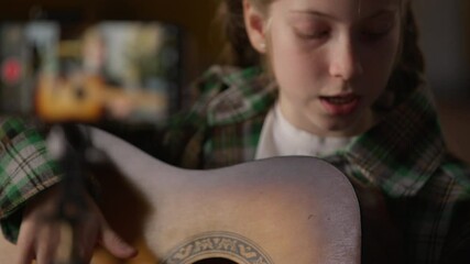 Mobile phone recording video little girl singing playing guitar music song at home Caucasian blogger influencer child kid schoolgirl play musical instrument filming stream smartphone practicing singer - Powered by Adobe