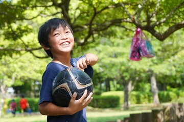 サッカーボールと笑顔の小学生の子供