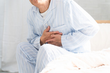 起きてベッドの上で胸を押さえている男性