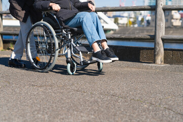 Obraz premium 車椅子を押して散策する熟年夫婦