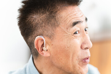 Obraz premium 補聴器を付けた熟年男性