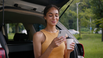 African American woman sitting trunk car auto automobile vehicle owner user mobile phone smartphone...