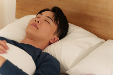 夜ベッドで寝る男性