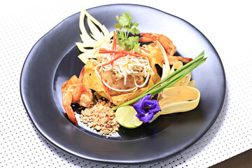 Shrimp Pad Thai, traditional Thai dish with stir fried rice noodles, shot from above on a rustic texture