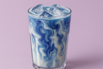 Iced blue latte with swirling patterns in glass, creative colorful dairy beverage on pastel lilac background, trendy refreshing drink