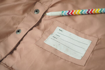 A label on soft pink fabric displays spaces for name and comments