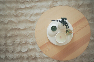 Decorative candles and plants arranged on a wooden table