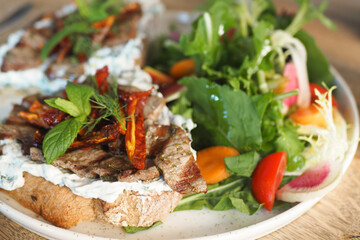 Delicious sandwich with grilled meat and fresh salad