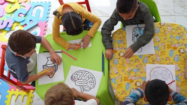 Preschool children sitting at a table coloring with their teacher. Kindergarten art activity encourages creativity, fine motor skills, and learning through play