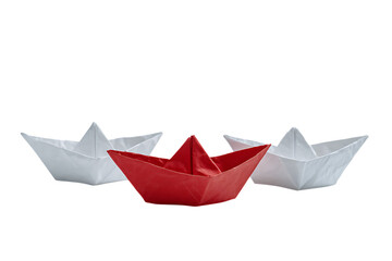 Red paper boat leads two white ones.  Concept of leadership, innovation, or standing out.