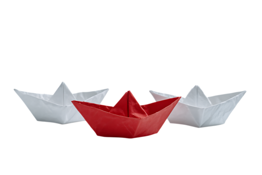 Red paper boat leads two white ones.  Concept of leadership, innovation, or standing out.