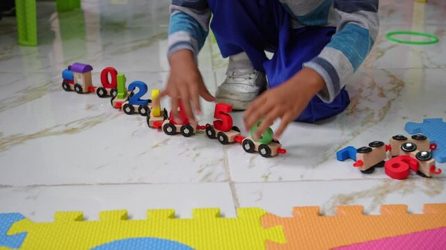 hispanic kindergarten boy playing with colorful number train on a foam alphabet mat. early math skills, and playful education, Children engaged in hands-on learning activities at a preschool classroom