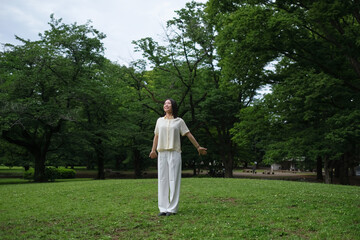 深呼吸をしながら森林浴を楽しむ女性