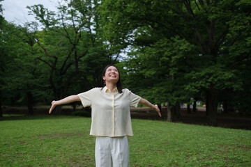 深呼吸をしながら森林浴を楽しむ女性