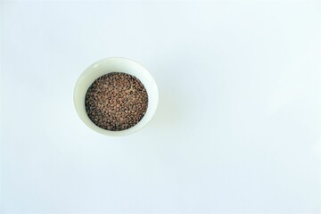 Coffee beans in a bowl on a white background. Copy space