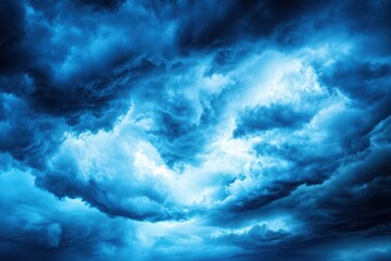 Obraz premium Dramatic Sky: A mesmerizing image of a turbulent sky, filled with swirling clouds. The celestial canvas showcases a spectrum of blues, creating a powerful and evocative spectacle of nature's grandeur.