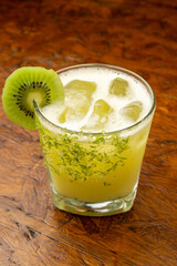 A refreshing Kiwi Margarita cocktail with lime zest rim and fresh kiwi slice garnish, a tropical...