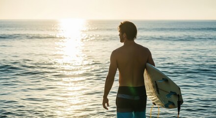 Male Surfer Walking in Ocean at Sunset with Surfboard