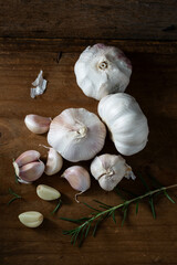 Fresh Garlic Bulbs and Cloves on Wooden Table with Rosemary Sprig
