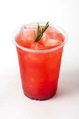 Refreshing Fruit Beverage with Ice and Herb Garnish in Clear Cup