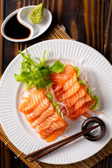 Fresh Salmon Sashimi on White Plate with Lettuce and Soy Sauce