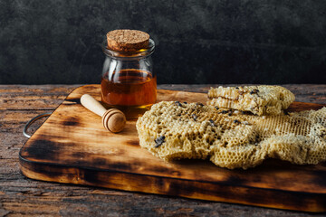 Fresh Honeycomb and Jar of Honey on Rustic Wooden Surface