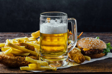 Delicious Beer with Crispy Fries and Tasty Burger on Table
