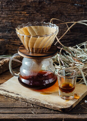 Coffee Brewing Setup with Filter and Glass Jug on Wooden Surface