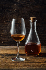 Elegant Glass of Amber Liquid Beside Vintage Bottle on Wooden Table