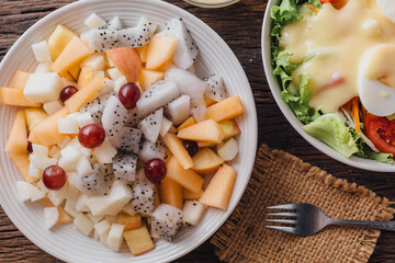 Fresh Mixed Fruit Salad with Dragon Fruit and Melon on Wooden Table