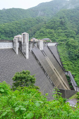 雨に煙る重力コンクリートダムである四万川ダム