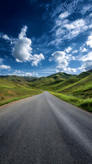 Scenic Road Through Rolling Green Hills Under a Bright Blue Sky with Clouds