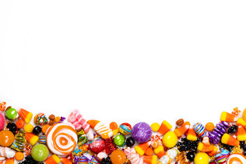 Colorful candy assortment displayed with a halloween border for festive celebrations.