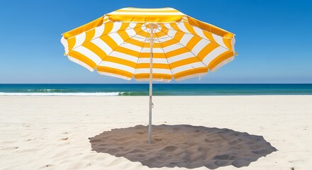 Yellow and white striped beach umbrella on a white sand beach under blue sky