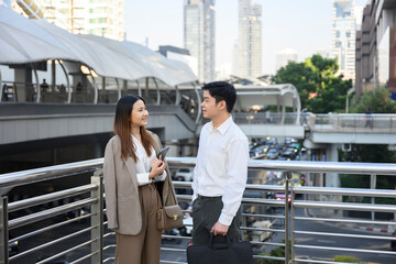 Businesspeople discussing work on footbridge in urban setting