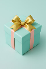 Obraz premium Mint green gift box mockup with golden bow and peach ribbon on pastel background for celebration, holiday packaging or luxury present branding design