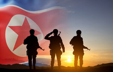 Silhouette of a soldiers against the sunset with North Korea flag