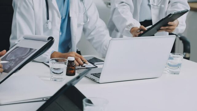 Male and female doctors are having a meeting in a hospital room.