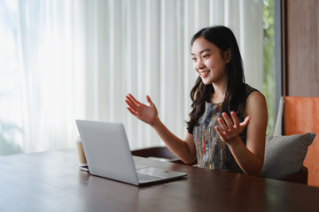 Young asian businesswoman having a video call on laptop in hotel room