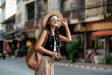 Young woman tourist adjusting sunglasses in old town street