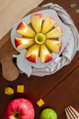 A close-up of a fresh red apple fruit on a round apple slicer.