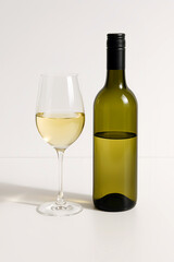 tall white glass with white in the glass and white bottle with white in the bottle half full, luxurious, slight shadow white background wide angle, full image with shadow
