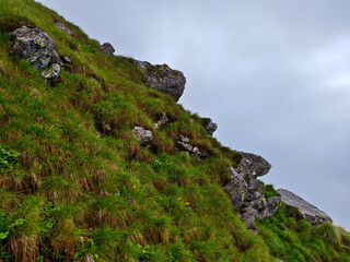 Rocky Grass-Covered Hillside Under Overcast Sky with Natural Terrain