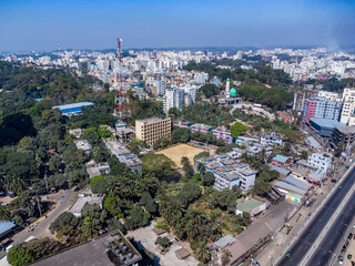Aerial view of a modern city with a highway running through it. Aerial view of Chittagong City with buildings, roads, and trees on a sunny day. Aerial View Cityscape of Chittagong City Bangladesh.