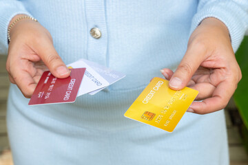 Woman holding several credit cards and he is choosing a credit card to pay and spend Payment for...