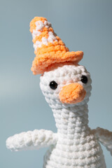 Crochet stuffed animal goose with a traffic cone on its head.