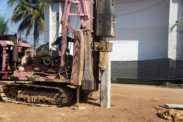 Fototapeta premium Drop Hammer of pile driver machine is driving square prestressed concrete pile into the ground at a construction site.