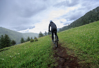 Obraz premium Riding mountain bike on grassland forest mountains