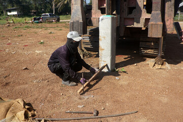 Worker measure the distance between pile driving positions.    